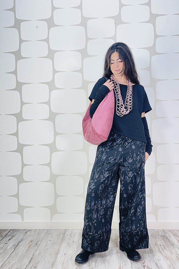 outfit con Maglia Genziana sartoriale nera, maniche sartoriali, Pantalone Verbania sartoriale, borsa toraian rosa e collana chain rosa